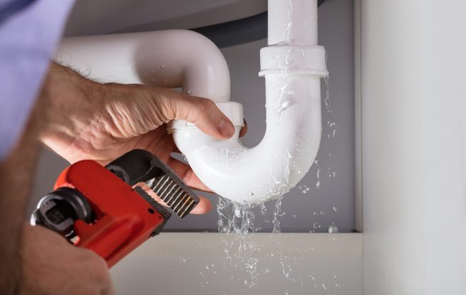 Close-up Of Male Plumber Fixing White Sink Pipe With Adjustable — Expert Plumbers in Miami, QLD