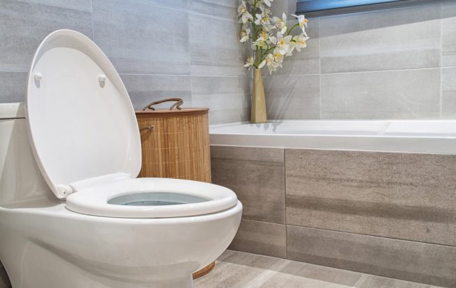 Bathroom with toilet bowl and bath tub in luxury house — Expert Plumbers in Robina, QLD